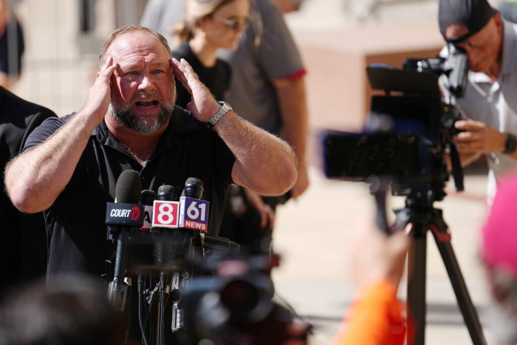 Alex-Jones-speaks-to-reporters-outside-a-courthouse-in-Connecticut.jpg