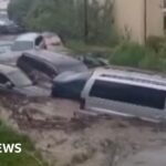 Cars have swept as the floods hit the south-eastern country